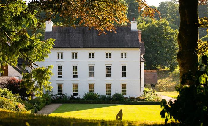 County house hotel exterior surrounded by greenery